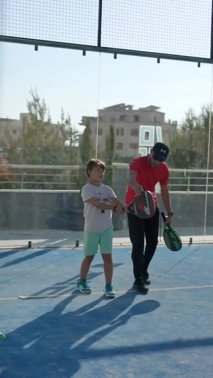 A 40 Love coach guides a young player's racket during a private class