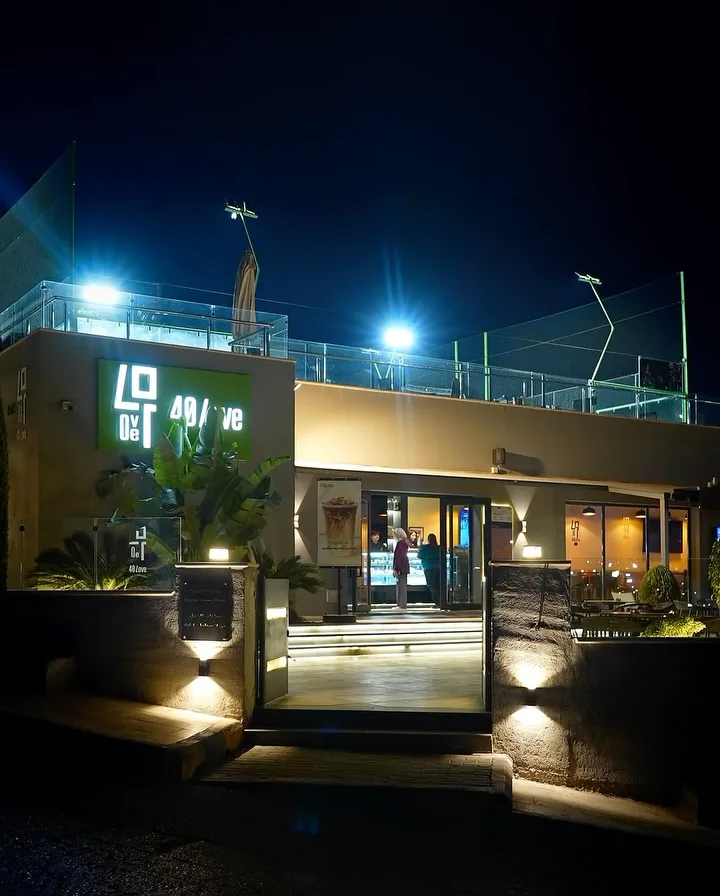 40 Love at night: the lit 40 Love sign over the entrance steps and the coffee house
