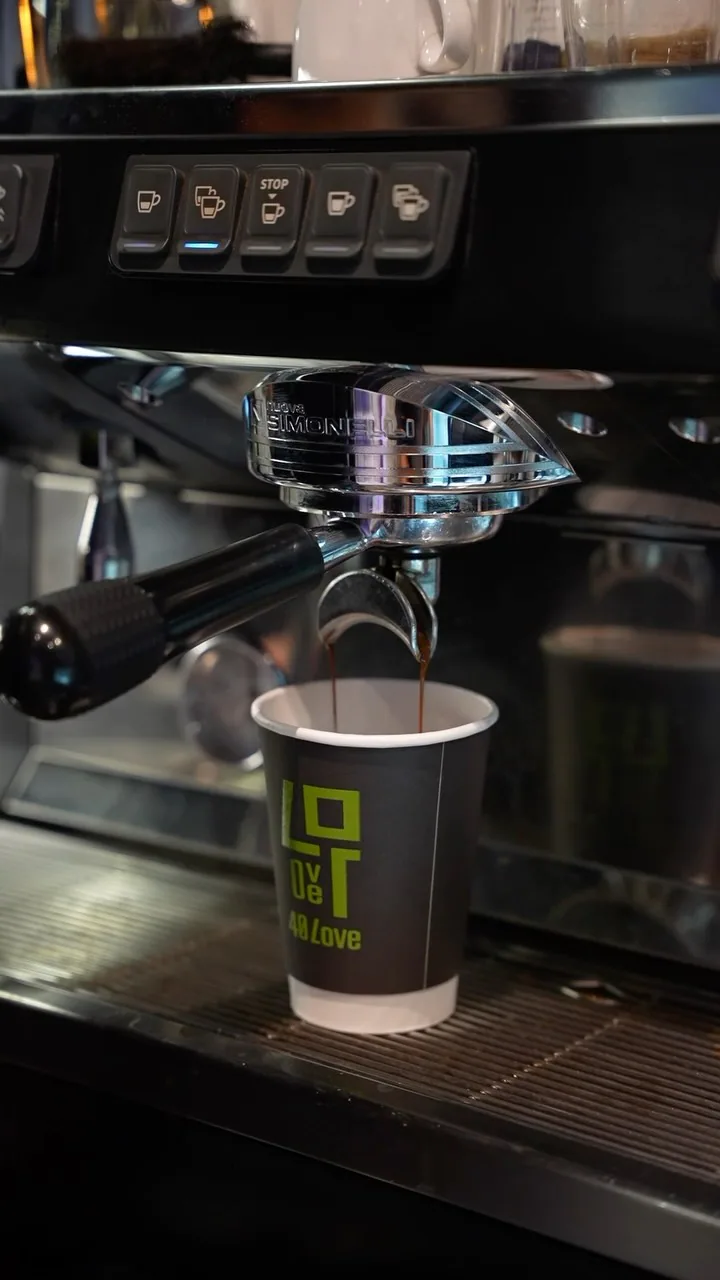 An espresso pours into a 40 Love cup at the coffee bar