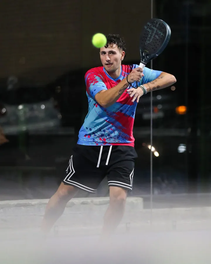 A player lines up a forehand under the floodlights at 40 Love